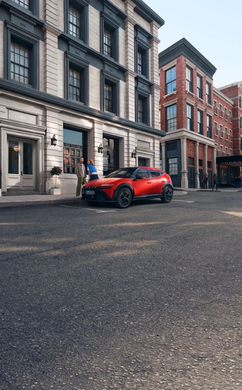 Eine Frau lehnt an der Motorhaube des an der Straße geparkten Hyundai IONIQ 3, eine Mann steht vor ihr.