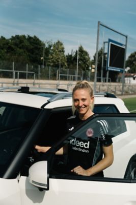 Rebecka Blomqvist steht in der geöffneten Fahrertür des Hyundai INSTER.