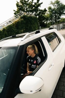 Rebecka Blomqvist sitzt lachend am Steuer des Hyundai INSTER.