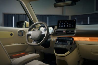 Blick in das vordere Interieur eines Hyundai INSTER mit Lenkrad, Displays und Bedienelementen.