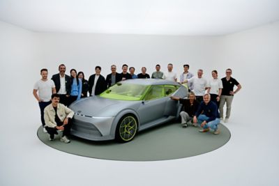 Gruppenbild des Design-Teams hinter dem E-Auto-Prototyp Hyundai Concept THREE.