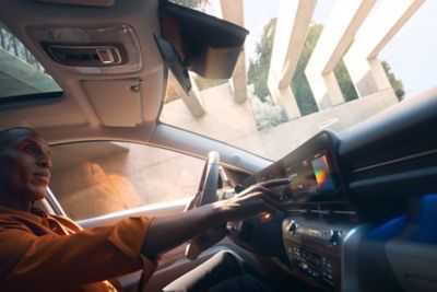 Ein Mann sitzt in einem Hyundai Fahrzeug und bedient das Touch-Display.