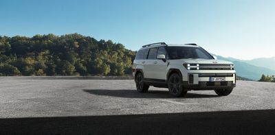 The new Hyundai Santa Fe Hybrid 7 seat SUV in grey pictured from the side parked.