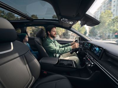 Innenansicht des Hyundai TUCSON Plug-in-Hybrid mit einem Fahrer am Steuer.