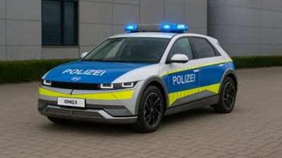 Ein Hyundai IONIQ 5 als Polizeiwagen steht auf einem kopfsteingepflasterten Platz.