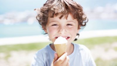 Ein lächelnder Junge mit einer Eiswaffel. 