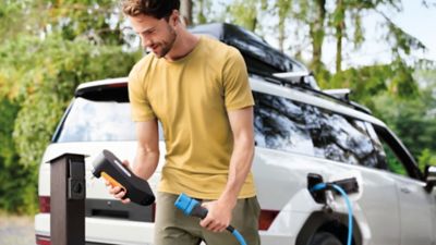 Ein Mann schließt ein Typ-2-Ladekabel an ein Mobility Dock an.