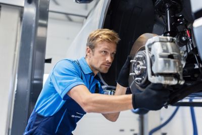 Ein Hyundai Service-Mitarbeiter arbeitet an der Hebebühne an der Bremsanlage eines Hyundai.