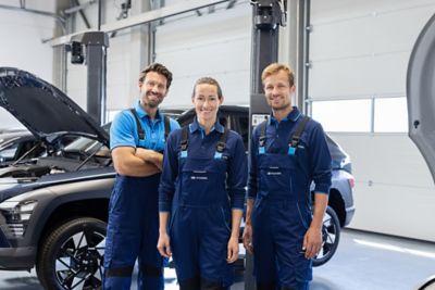 Ein Hyundai Service Mitarbeiter in einer Werkstatt, im Hintergrund Fahrzeuge auf Hebebühnen.