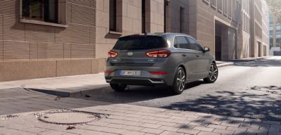 Ein Hyundai i30, schräg von hinten gesehen, parkt vor einem städtischen Gebäude.