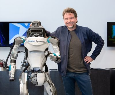 Marc Theerman, Chief Strategy Officer von Boston Dynamics mit einem Roboter.