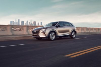 Seitenansicht eines Hyundai Nexo mit Wasserstroffantrieb vor einer urbanen Skyline.