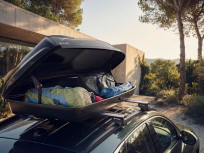Hyundai med öppen takbox lastad med bagage för sommarresan.