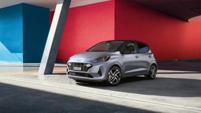 La Hyundai i10 parcheggiata davanti a un muro rosso e blu.