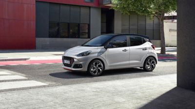 The new Hyundai i10 in white parked in front of a building.