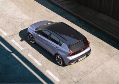 La Hyundai BAYON bleue roule dans une rue.