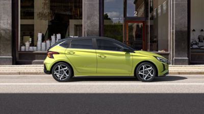 Hyundai i20 vo farbe Lucid Lime Metallic  parkujúci pred obchodom.