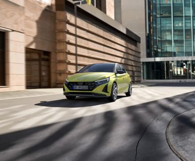 Hyundai i20 Lucid Lime Metallic parked in front of the building.