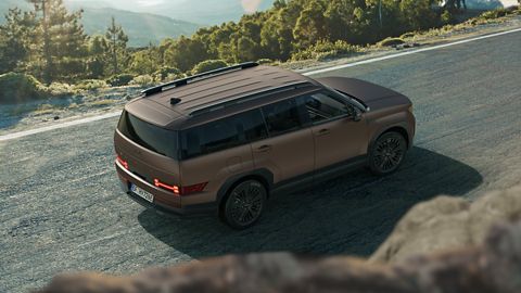 Hyundai SANTA FE estacionado en un parking rodeado de paisaje natural, un hombre hace una foto con cámara al paisaje.