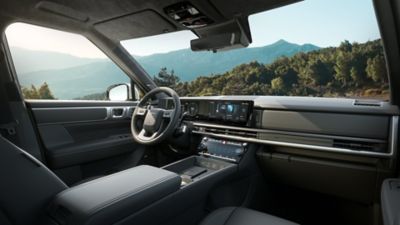 Het interieur van de Hyundai SANTA FE, met zicht op het stuurwiel, de middenconsole en het dashboard.