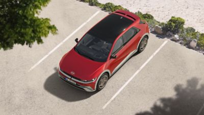 Driekwart vooraanzicht Hyundai IONIQ 5 rijdend in bocht op betonnen helling.