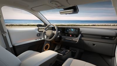 Interior of new Hyundai IONIQ 5 cockpit showing the steering wheel plus a view of the sea outside.