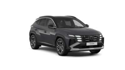 The Hyundai TUCSON Plug-in Hybrid driving down a city street with modern buildings visible.