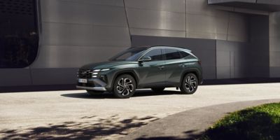 Hyundai TUCSON Hybrid garé près d’un bâtiment à l’architecture moderne.