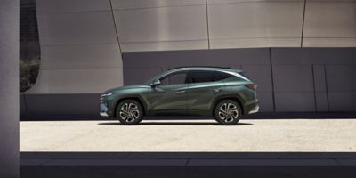 The Hyundai TUCSON Plug-in Hybrid parked next to a building.