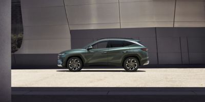 The Hyundai TUCSON Plug-in Hybrid parked next to a modern building.