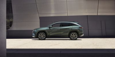 The Hyundai TUCSON Plug-in Hybrid parked next to a modern building.