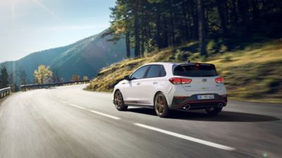 The new Hyundai i30 N Drive-N Limited Edition in Phantom Black Pearl driving on a curvy road.