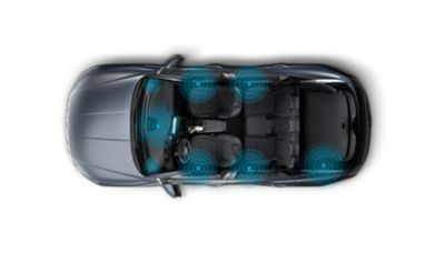 Obrázek Hyundai TUCSON Plug-in Hybrid z ptačí perspektivy se zvýrazněnými výkonnými reproduktory a subwooferem.
