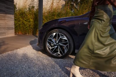 Front alloy of IONIQ 6 with woman walking past.