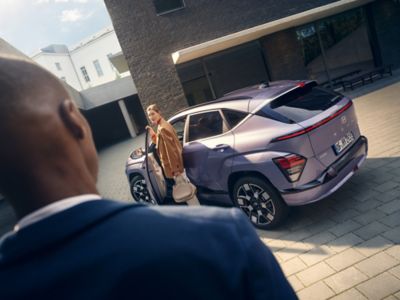 The Hyundai KONA Electric SUV shown from the front with a man and a woman.