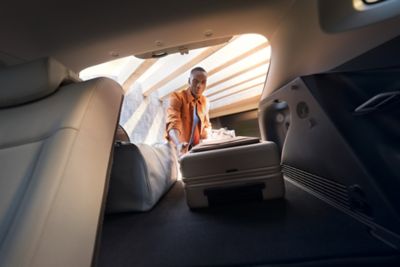 A man loading luggage into the Hyundai KONA Electric