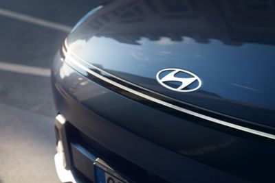A close-up image of the front hood and Hyundai emblem of the all-new Hyundai KONA. 	