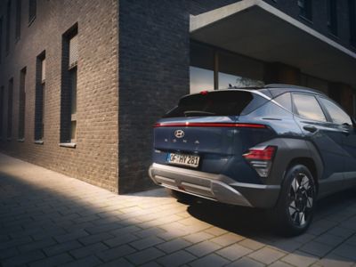 The all-new Hyundai KONA in blue parked next to a building.