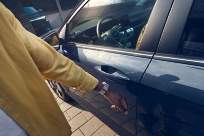 A man opening the door of Hyundai KONA using a smartphone and Hyundai Digital Key 2 Touch.