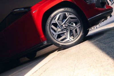 The bolder and sportier 18" alloy wheels in a geometric form of the Hyundai KONA N Line in red. 
