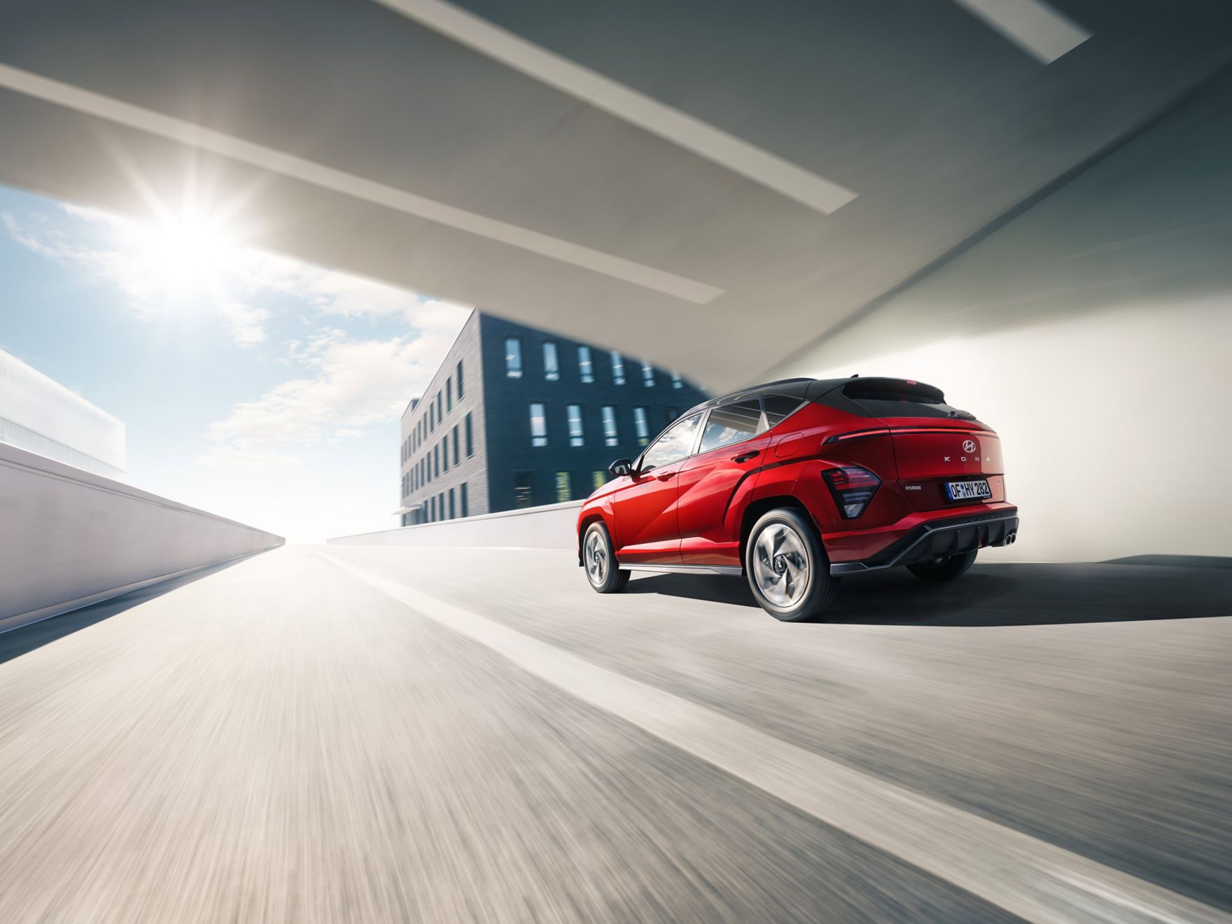 The all-new Hyundai KONA pictured from the side driving down a city street. 