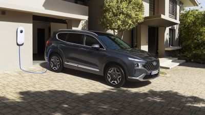 Ein Hyundai SANTA FE Plug-in Hybrid beim Aufladen.