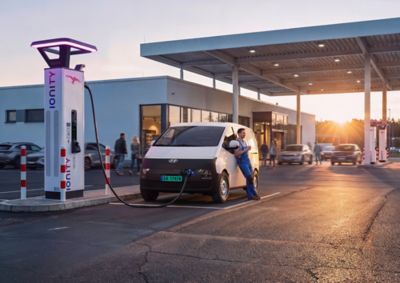 STARIA Electric Varebil står og lader ved en hurtiglader. Foto.