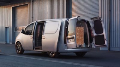 Driekwart achteraanzicht Hyundai STARIA Cargo met geopende schuifdeur en geopende dubbele achterdeuren.