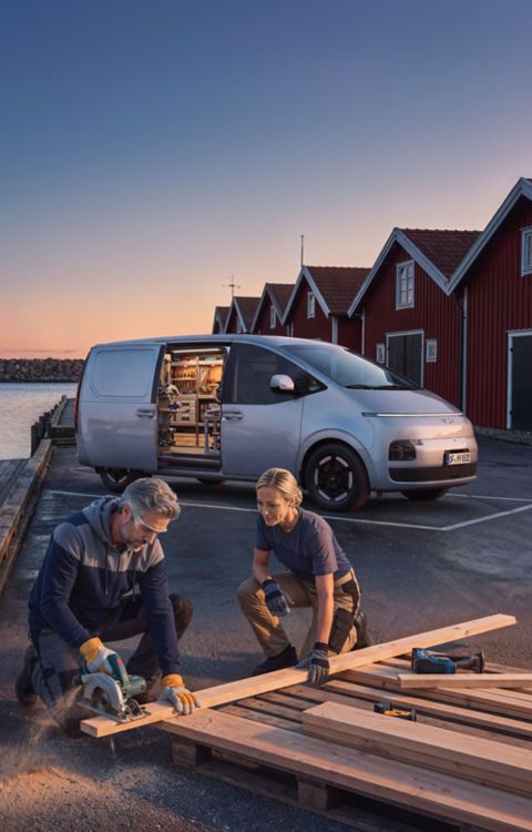 To håndverkere arbeider ved siden av en STARIA Electric Varebil. Foto