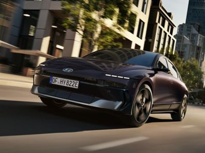 Hyundai IONIQ 6 kör på en stadsväg och visar sin strömlinjeformade design.
