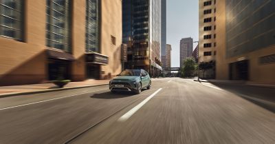 The BAYON compact crossover SUV driving in a city street from the front