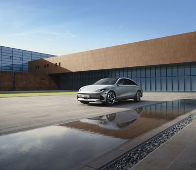 The Hyundai IONIQ 6 parked next to a modern building