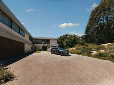 The Hyundai TUCSON Plug-in Hybrid parked next to a house with trees.