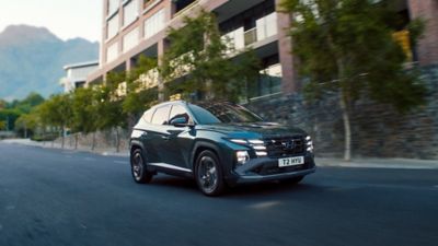 Hyundai TUCSON plug-in hybrid driving down a road.